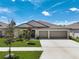 Three-car garage and neat lawn characterize this single-story house at 288 Rain Berry Ave, Ruskin, FL 33570