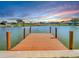 Wooden dock extending over calm water with a sunset in the background at 1707 Tahoe Dr, Sun City Center, FL 33573