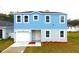 Two-story house with blue siding, white garage door, and landscaping at 3708 Wiggins Leaf St, Tampa, FL 33619
