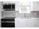 Modern kitchen with white cabinets, stainless steel appliances, and a quartz countertop at 3708 Wiggins Leaf St, Tampa, FL 33619