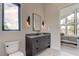 Modern bathroom with dark vanity, floating sink, and a view into a bedroom at 9586 Troutwater Ln, Tampa, FL 33618