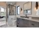 Contemporary bathroom with glass shower, dark vanity, and a view into an office at 9586 Troutwater Ln, Tampa, FL 33618
