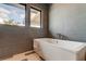 Freestanding bathtub with modern faucet and large windows at 9586 Troutwater Ln, Tampa, FL 33618