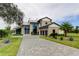 Luxury home with stone accents and a large driveway at 9586 Troutwater Ln, Tampa, FL 33618