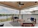Covered patio with lake view, modern furniture, and wood ceiling at 9586 Troutwater Ln, Tampa, FL 33618