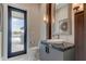 Stylish powder room with dark vanity, vessel sink, and backyard access at 9586 Troutwater Ln, Tampa, FL 33618