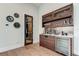 Elegant wet bar with wooden cabinetry, a beverage fridge, and a quartz countertop at 9586 Troutwater Ln, Tampa, FL 33618