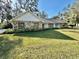 Ranch style home with stone facade, spacious lawn, and mature trees at 1501 Buell Ct, Plant City, FL 33567