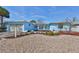 Light blue home exterior, landscaped yard, and pebble driveway at 909 Birdie Way, Apollo Beach, FL 33572