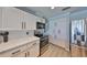 White kitchen features marble countertops, stainless steel appliances, and ample cabinet space at 909 Birdie Way, Apollo Beach, FL 33572