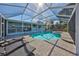 Inviting pool area with covered patio, lounge chairs, and lush landscaping at 909 Birdie Way, Apollo Beach, FL 33572