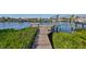 Wooden walkway leads to a private dock with boat lift at 909 Birdie Way, Apollo Beach, FL 33572
