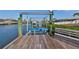 Spacious wooden dock with boat lift and seating area at 909 Birdie Way, Apollo Beach, FL 33572
