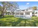 Spacious backyard with a swimming pool, large lawn, mature trees, and a white fence at 4010 W Watrous Ave, Tampa, FL 33629