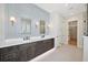 Bathroom with a double vanity, decorative sconces and a view into the walk-in closet at 4010 W Watrous Ave, Tampa, FL 33629