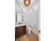 Stylish powder room with a marble vanity, hardwood floors and modern light fixture at 4010 W Watrous Ave, Tampa, FL 33629