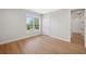Bright bedroom with hardwood floors and large window with views of mature trees and a street at 4010 W Watrous Ave, Tampa, FL 33629