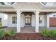 Inviting entryway featuring a covered porch, brickwork, and manicured landscaping at 4010 W Watrous Ave, Tampa, FL 33629