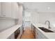 Bright kitchen with stainless steel appliances, white cabinets, quartz countertops, and hardwood floors at 4010 W Watrous Ave, Tampa, FL 33629