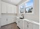 Bright laundry room with lots of cabinets, white countertops and a large window at 4010 W Watrous Ave, Tampa, FL 33629