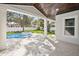 A covered outdoor space overlooking the pool with a spa and lush landscaping at 4010 W Watrous Ave, Tampa, FL 33629