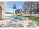 Backyard with a sparkling swimming pool, hot tub, white fence, and green lawn at 4010 W Watrous Ave, Tampa, FL 33629