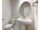 Modern powder room with pedestal sink, toilet, and oval mirror at 16111 69Th E Ln, Parrish, FL 34219