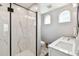 Elegant bathroom with marble shower, double vanity, and arched windows at 704 S Newport Ave, Tampa, FL 33606