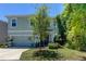 Two-story house with light blue exterior, two-car garage, and landscaping at 7516 Cypress Walk Dr, New Port Richey, FL 34655