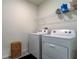 Bright laundry room with washer, dryer, and shelving at 7516 Cypress Walk Dr, New Port Richey, FL 34655