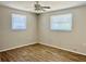 Bedroom with wood-look floors, ceiling fan, and ample light at 3615 Wellington Dr, Holiday, FL 34691