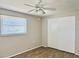 Bedroom with wood-look floors, ceiling fan, and large closet at 3615 Wellington Dr, Holiday, FL 34691