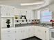 White kitchen with gray countertops and updated appliances at 3615 Wellington Dr, Holiday, FL 34691