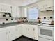 White kitchen with gray countertops and updated appliances at 3615 Wellington Dr, Holiday, FL 34691