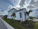 Two-story home with light gray siding, covered porch, and landscaping at 1574 Running Tide Pl, Sarasota, FL 34240