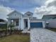 Two-story home with light blue siding, gray roof, and a two-car garage at 1574 Running Tide Pl, Sarasota, FL 34240