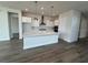 Modern kitchen with white cabinets, large island, and hardwood floors at 1574 Running Tide Pl, Sarasota, FL 34240