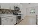 Modern kitchen with white cabinets and stainless steel appliances at 12814 Cattail Shore Ln, Riverview, FL 33579