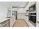 Modern white kitchen with stainless steel appliances and an island at 9305 Barnacle Ln, Parrish, FL 34219