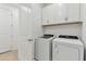 Laundry room with white cabinets and matching washer and dryer at 9305 Barnacle Ln, Parrish, FL 34219