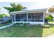 House exterior featuring a screened porch and landscaped yard at 4483 Flounder Dr, Hernando Beach, FL 34607