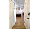 Hallway view leading to a bedroom with wood-look flooring and white trim at 3639 Hurston St, New Port Richey, FL 34655