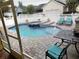 Backyard pool area with patio, lounge chairs, and a white picket fence at 3639 Hurston St, New Port Richey, FL 34655