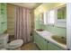 Clean bathroom with light green vanity, shower/tub combo and shelving at 116 W Saint Johns Way, Apollo Beach, FL 33572