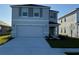 Two-story house with gray siding, two-car garage, and landscaping at 10225 Kalamazoo Pl, Parrish, FL 34219