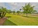 Landscaped backyard with grassy area and trees at 1817 Pacific Dunes Dr, Sun City Center, FL 33573