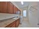 Laundry room with cabinets, granite countertop, and shelving at 1817 Pacific Dunes Dr, Sun City Center, FL 33573