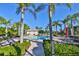 Community pool area with palm trees, lounge chairs, tables, and lush landscaping at 1817 Pacific Dunes Dr, Sun City Center, FL 33573