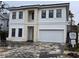 Two-story home with white and beige exterior, two-car garage, and a paved driveway at 3707 W San Juan St, Tampa, FL 33629