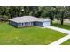 Single-story home with gray siding, stone accents, and a two-car garage at 11734 Orange Ct, Dade City, FL 33525